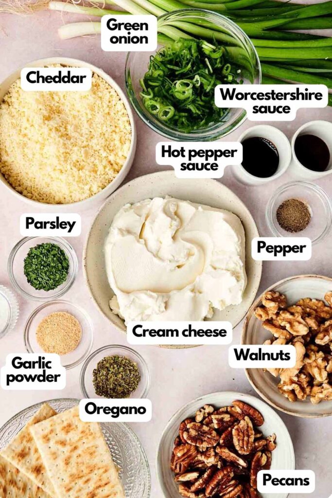 Ingredients for a dish are displayed, including green onion, cheddar, Worcestershire sauce, hot pepper sauce, parsley, pepper, cream cheese, walnuts, garlic powder, oregano, and pecans.