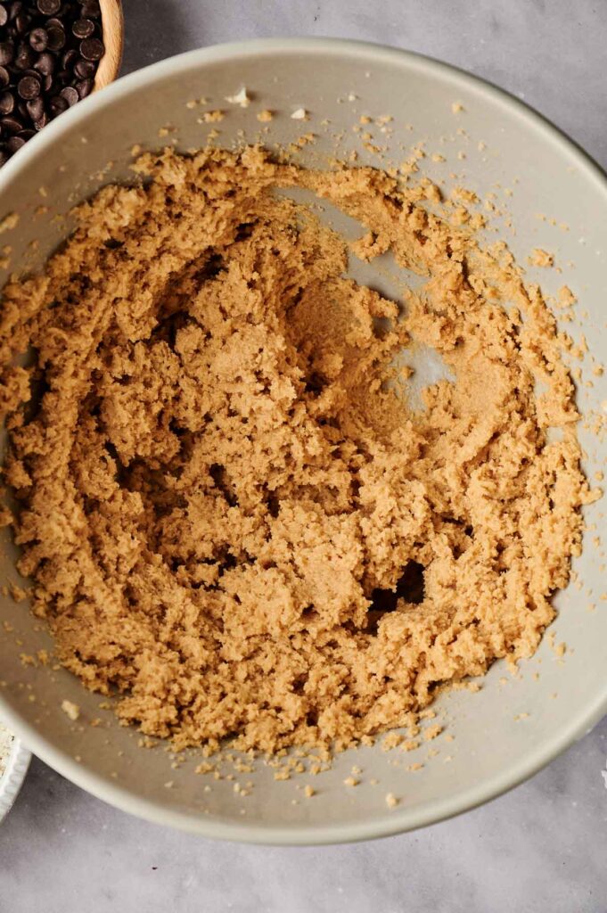 A bowl of mixed cookie dough is on a countertop.