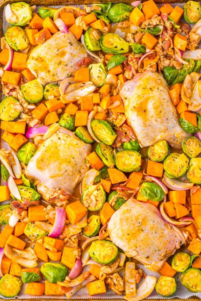 Maple Dijon chicken thighs paired with Brussels sprouts, sweet potatoes, red onions, and walnuts all come together harmoniously on a sheet pan.
