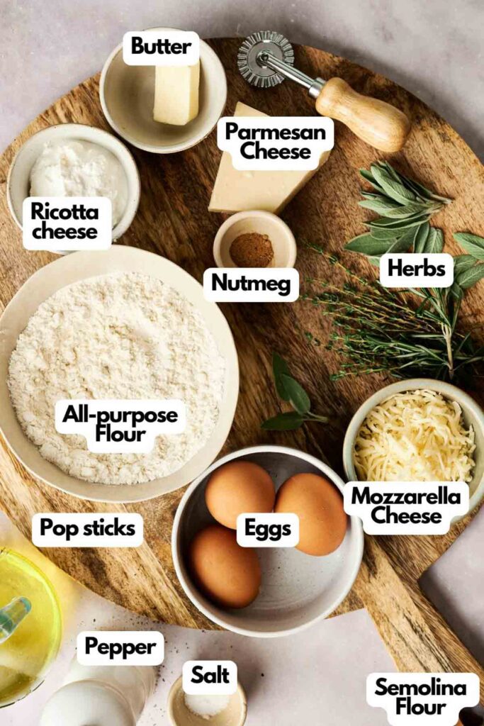 Learn how to make ravioli with a medley of ingredients artfully displayed on a wooden board: flour, ricotta and mozzarella cheese, eggs, herbs, nutmeg, Parmesan cheese, butter, semolina flour, pop sticks for easy handling, salt, pepper, and oil.