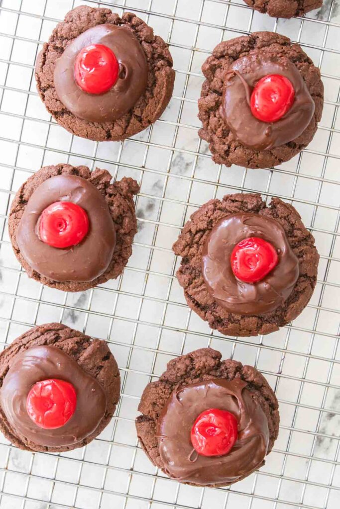 Chocolate cherry cookies perfectly arranged on a cooling rack, their rich cocoa flavor complemented by vibrant cherries on top.