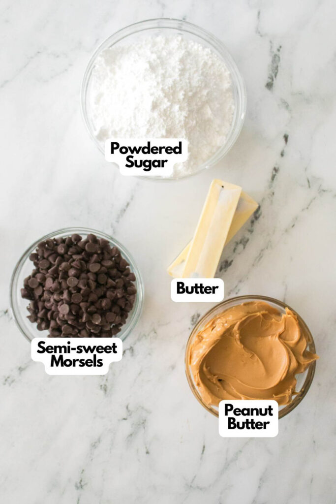 On a marble surface, the ingredients for homemade buckeyes are neatly arranged: powdered sugar, butter sticks, semi-sweet chocolate morsels, and peanut butter in separate containers.