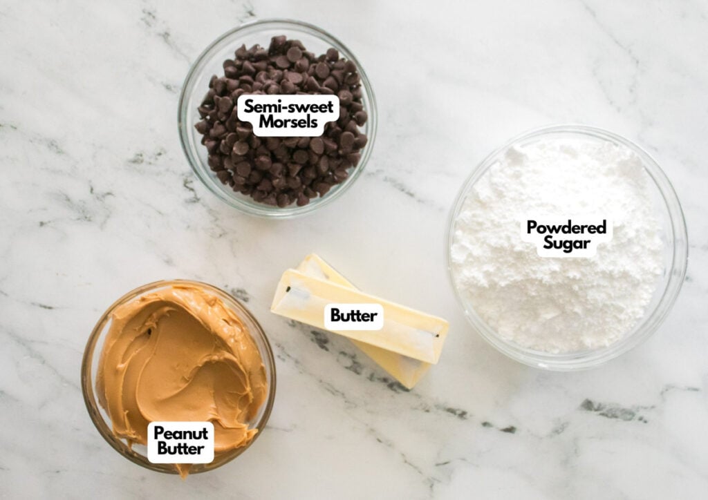 A marble surface displays bowls of semi-sweet chocolate chips, powdered sugar, peanut butter, and two sticks of butter&mdash;all labeled&mdash;for making homemade buckeyes.