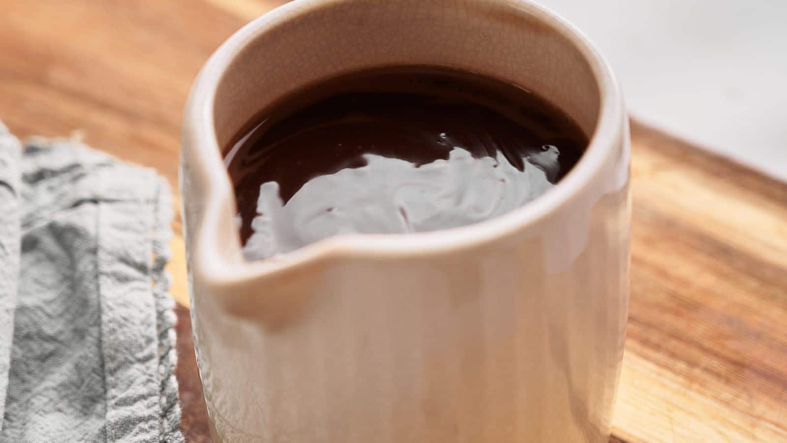 Hot fudge sauce being stirred in a pan.