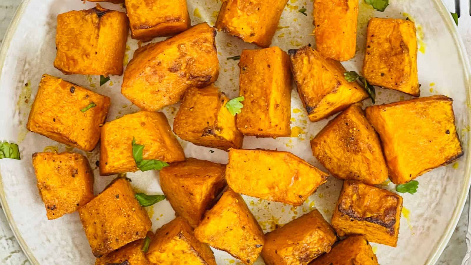 Air Fryer Pumpkin garnished with green herbs on a white plate.