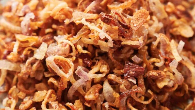 Close-up of golden brown fried shallots, crispy and thinly sliced.