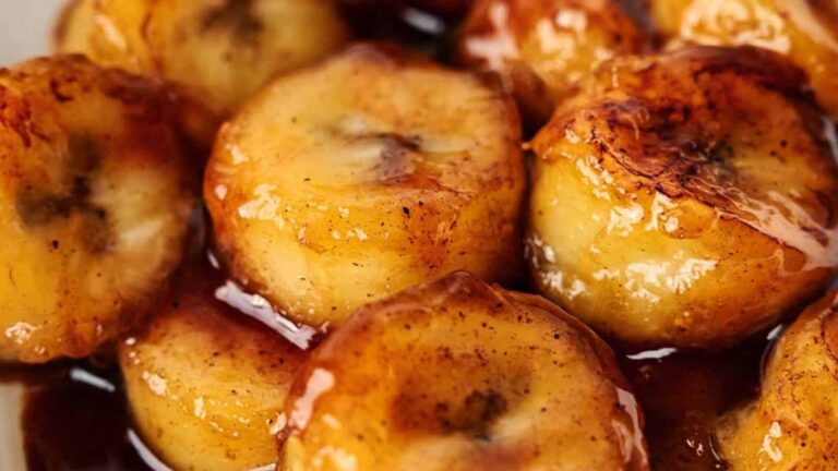 Close-up of caramelized banana slices with a glossy, browned appearance, coated in a rich syrup.