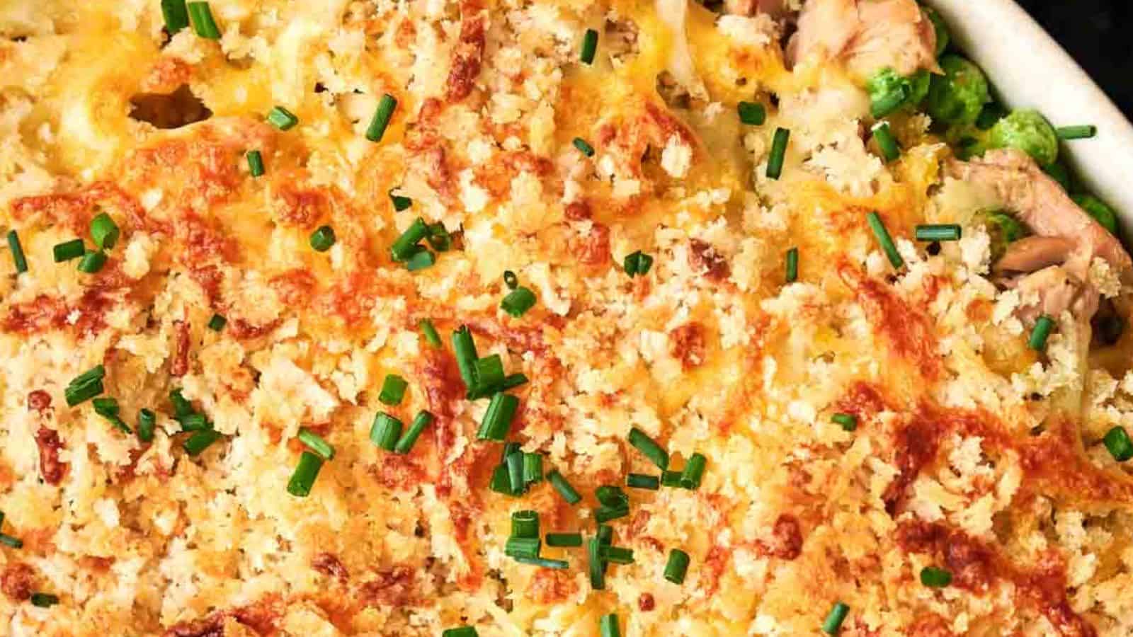 A close-up of a baked dish topped with golden bread crumbs and chopped chives.