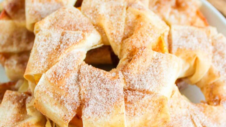 A close-up of a pastry wreath sprinkled with cinnamon sugar.