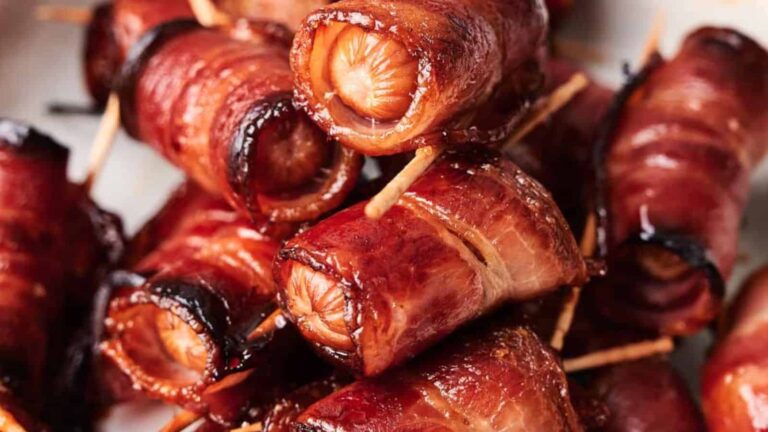 Bacon-wrapped sausages secured with toothpicks, cooked to a golden brown.