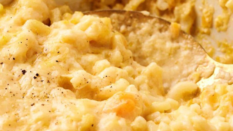 Close-up of creamy macaroni and cheese with black pepper sprinkled on top.