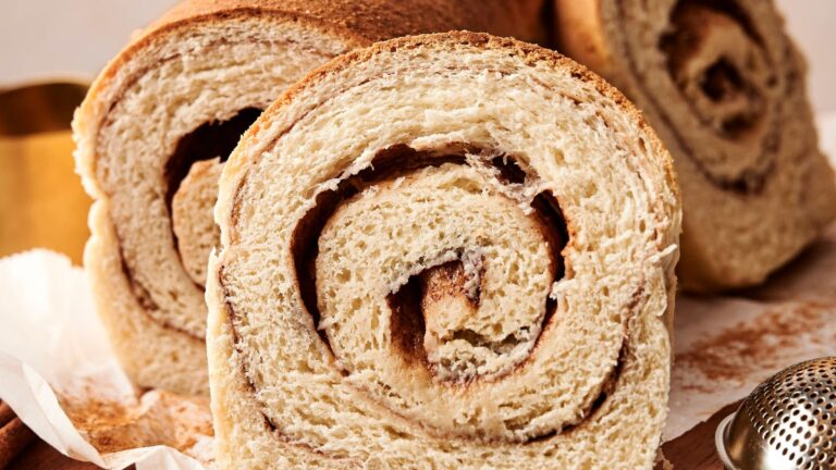 Close-up of sliced cinnamon swirl bread, showing the spiral pattern of cinnamon within the soft, textured bread.