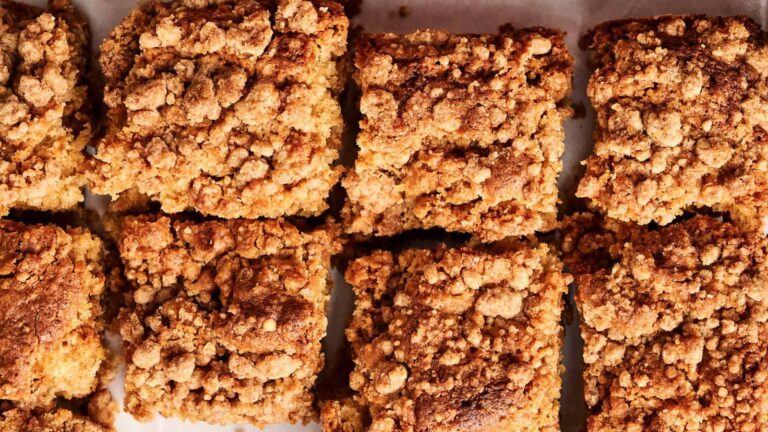 Close-up of nine square pieces of crumb cake with a golden, crumbly topping.