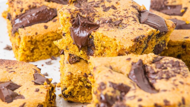 Close-up of pumpkin chocolate chunk bars stacked on a plate.