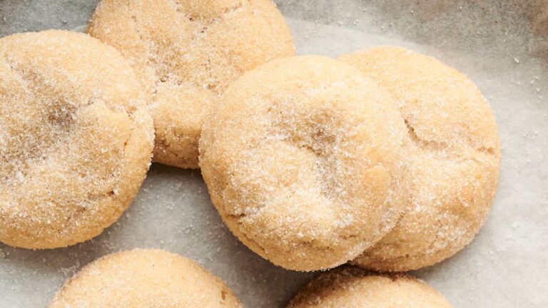 Close-up of several sugar-coated cookies on parchment paper.