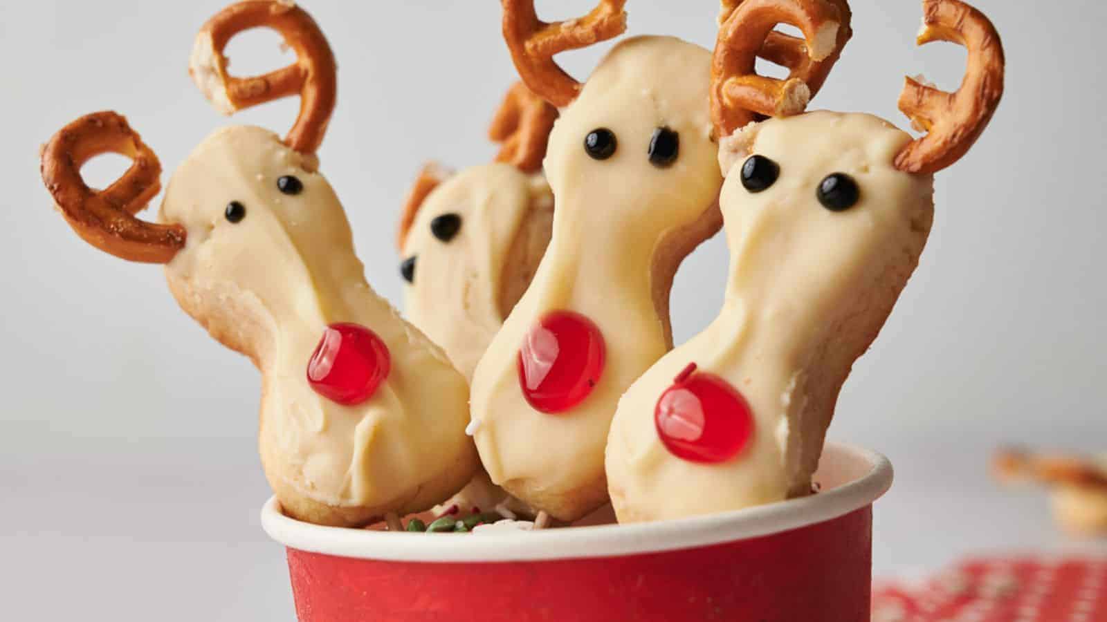 Reindeer cookie pops in a cup.