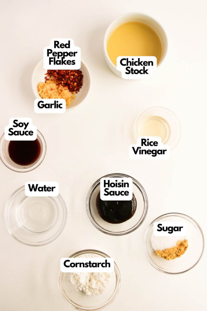 Labeled ingredients for General Tso’s Chicken on a white background: chicken stock, red pepper flakes, garlic, soy sauce, rice vinegar, hoisin sauce, water, sugar, and cornstarch.