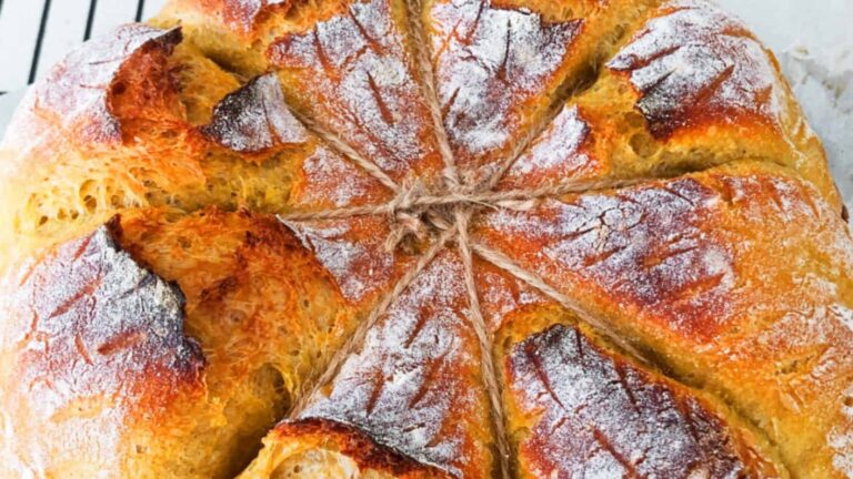 Artisan bread with a star-shaped pattern, dusted with flour and baked to a golden crust.