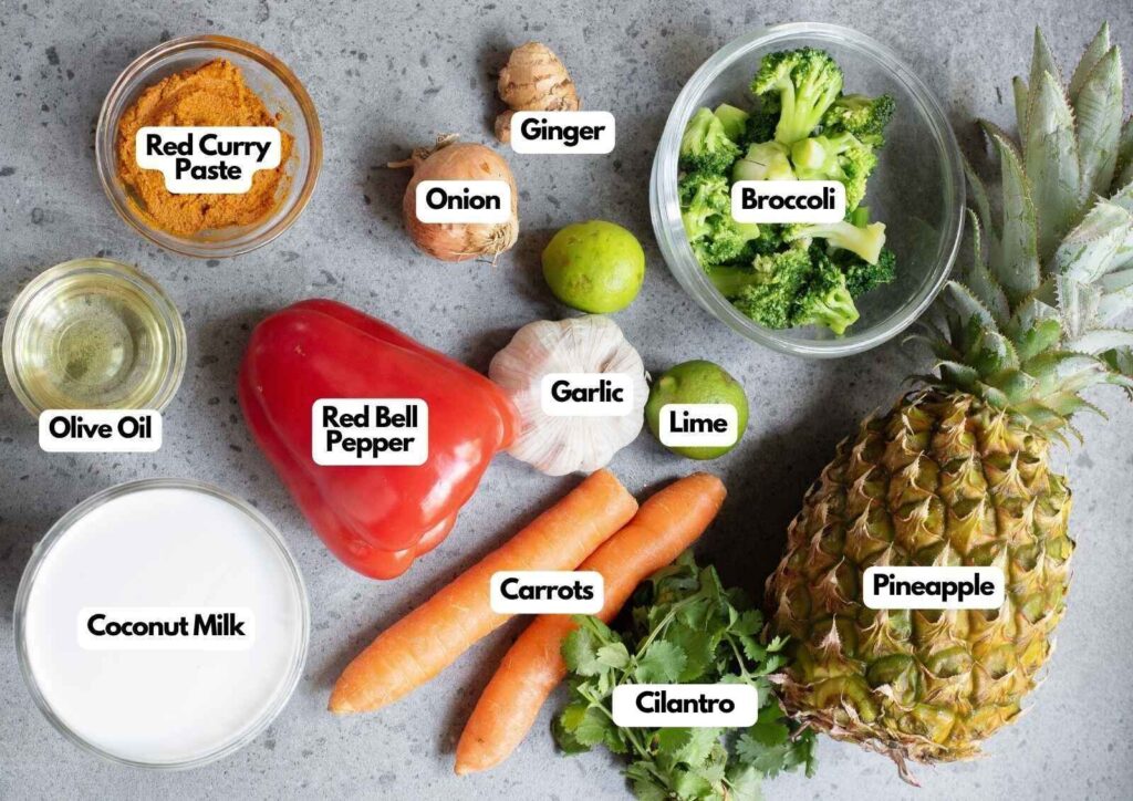 Assorted vegetables, herbs, and ingredients including pineapple, broccoli, carrots, red bell pepper, onion, lime, ginger, garlic, cilantro, coconut milk, red curry paste, and olive oil come together to create a vibrant Thai Coconut Curry.