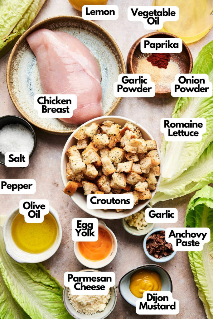 Ingredients for Chicken Caesar Salad include chicken breast, romaine lettuce, croutons, parmesan cheese, garlic, anchovy paste, olive oil, lemon juice, egg yolk, onion powder, garlic powder, paprika, and mustard.