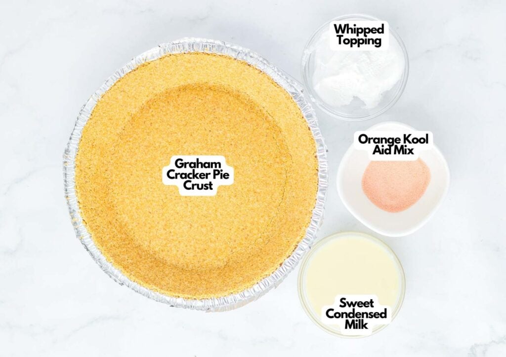A graham cracker pie crust, whipped topping, orange Kool Aid mix, and sweetened condensed milk on a white surface—everything you need to make a refreshing Kool Aid Pie.