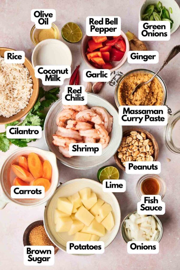 A top view showcases an array of ingredients labeled for a Massaman curry recipe, featuring shrimp, red bell pepper, coconut milk, and spices, all artfully arranged on a light surface.