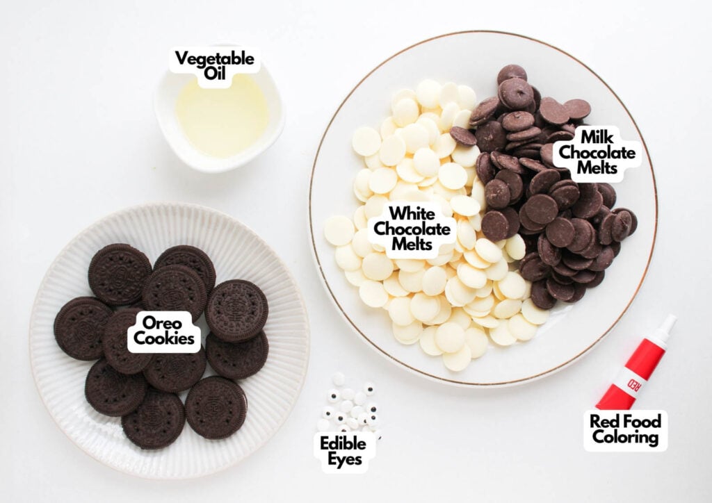 Three bowls hold vegetable oil, Oreo cookies, and edible eyes; a larger plate displays white and milk chocolate melts for making Ladybug Chocolate Covered Oreos, alongside a tube of red food coloring.