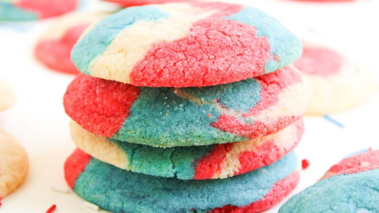 A stack of sugar cookies with red, blue, and white marbled colors on a white surface.