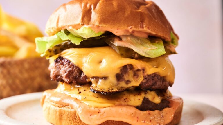 A hamburger with cheese and lettuce on it.