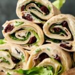 Six Turkey Pinwheels tortilla wraps filled with lettuce, cream cheese, and dried cranberries, stacked in a pyramid shape.