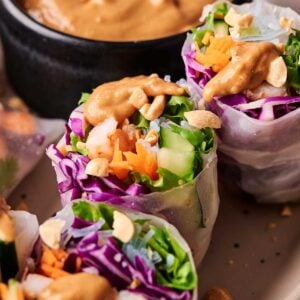 Enjoy our Spring Roll with Shrimp, packed with lettuce, purple cabbage, cucumber, and carrots, topped with chopped peanuts and served alongside a savory bowl of peanut dipping sauce.