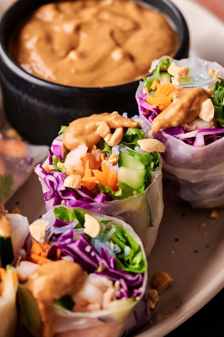 Enjoy our Spring Roll with Shrimp, packed with lettuce, purple cabbage, cucumber, and carrots, topped with chopped peanuts and served alongside a savory bowl of peanut dipping sauce.