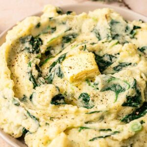 A bowl of Colcannon—mashed potatoes mixed with spinach, topped with a pat of butter and sprinkled with black pepper.