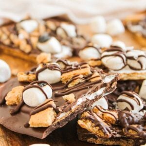 Loaded S'mores Bark featuring chocolate bark topped with mini marshmallows, graham cracker pieces, and a drizzle of chocolate, all beautifully arranged on a wooden surface.