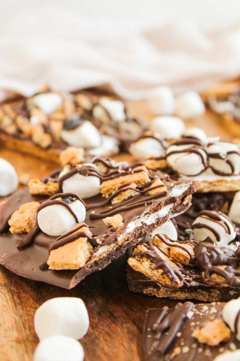 Loaded S'mores Bark featuring chocolate bark topped with mini marshmallows, graham cracker pieces, and a drizzle of chocolate, all beautifully arranged on a wooden surface.
