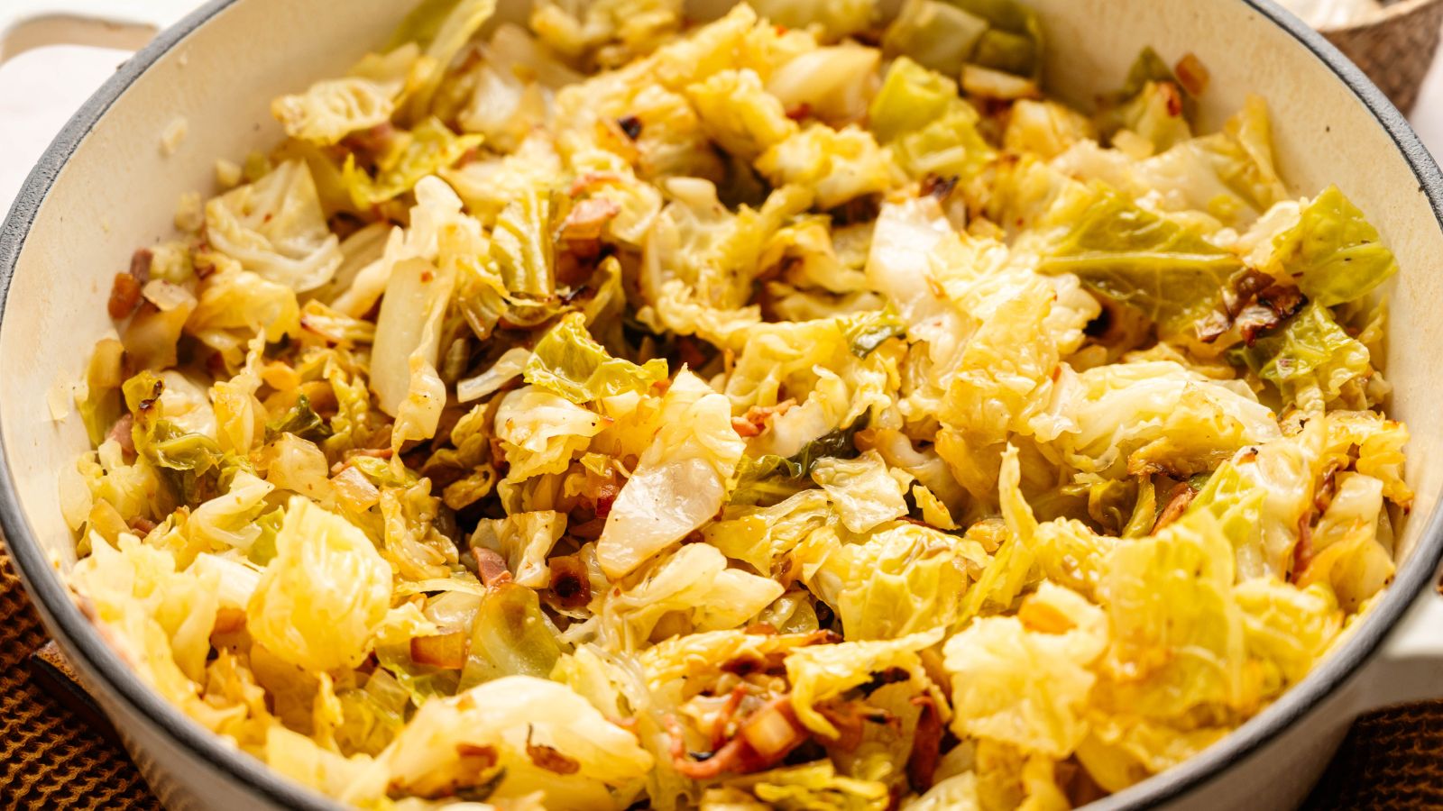 Cooked cabbage with onions and seasonings in a large pot.