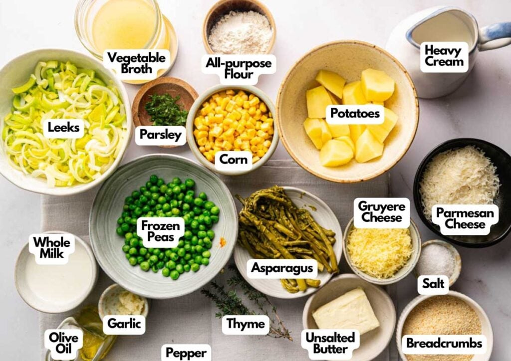 Various labeled ingredients for an Air Fryer Easter Casserole are arranged on a table, including leeks, potatoes, corn, peas, cheese, broth, flour, milk, and seasonings.
