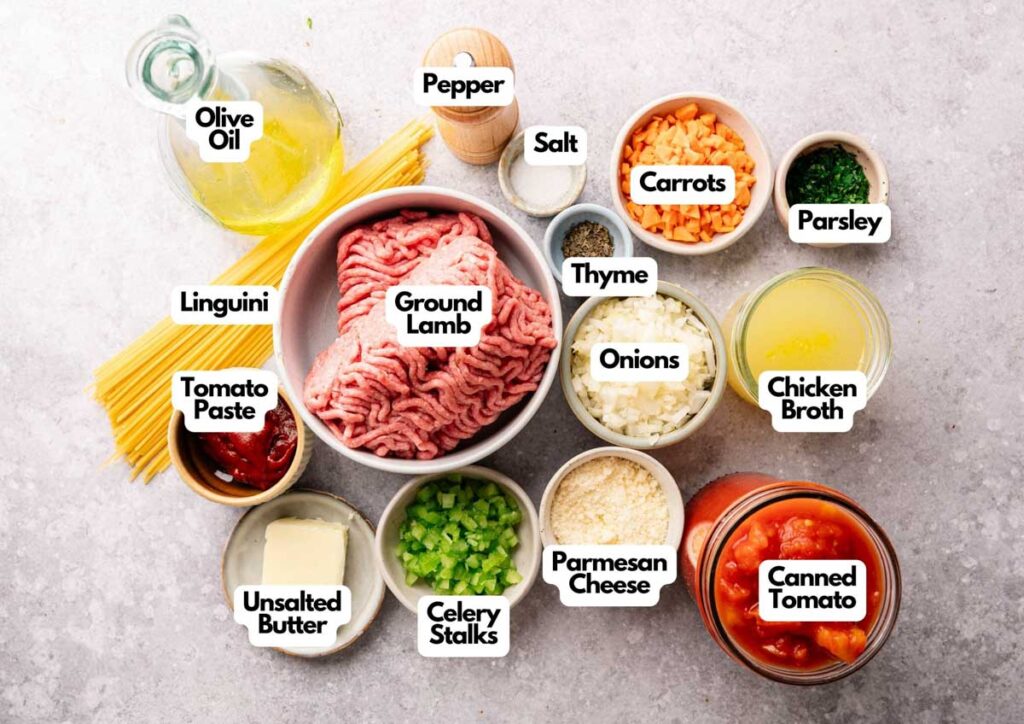 Top-down view of labeled ingredients for a Lamb Bolognese pasta dish, including ground lamb, linguini, canned tomato, vegetables, herbs, broth, olive oil, butter, and cheese.